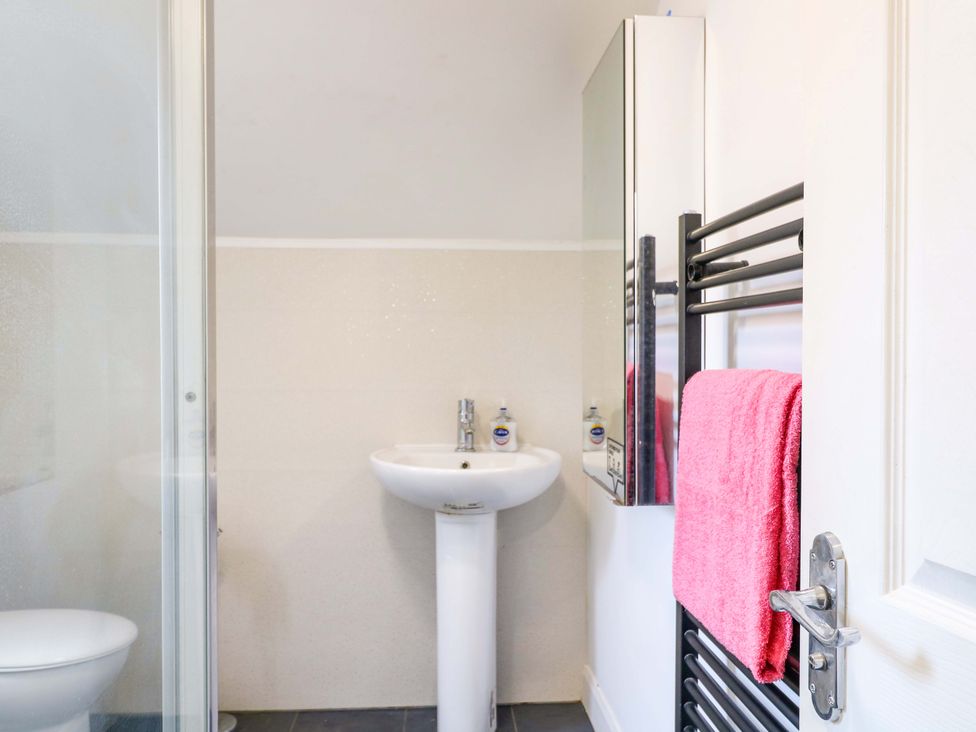 A bathroom with a sink, shower, and towel rail at 57 Abbey Street