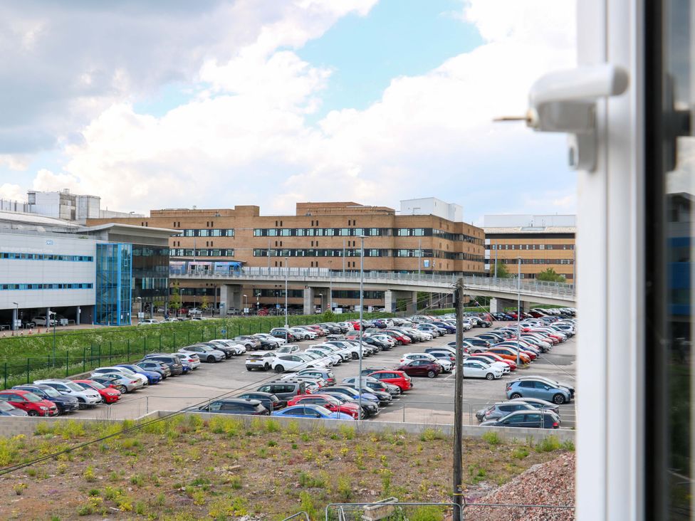 A view of a parking lot with cars and buildings at 57 Abbey Street