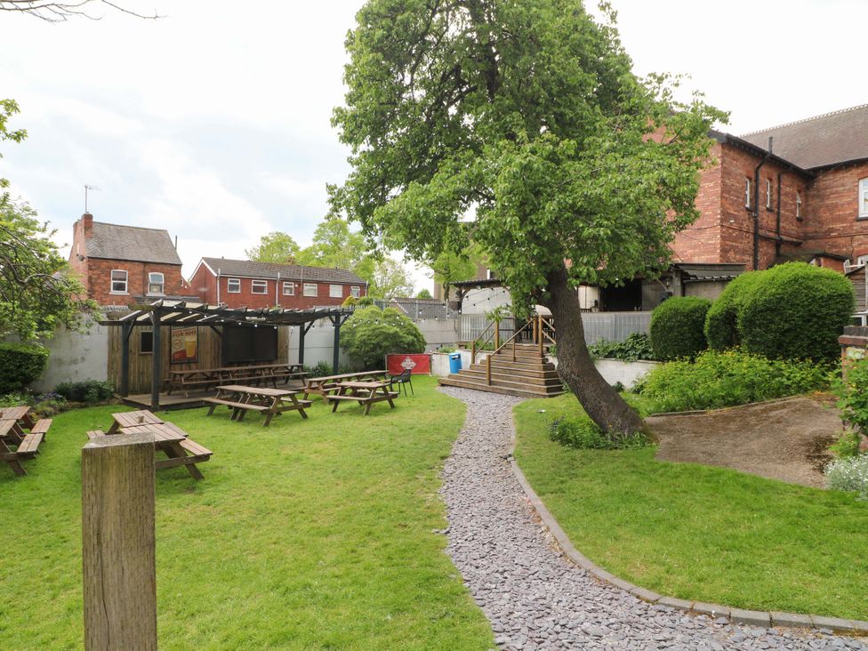 A garden with benches and a pathway at 57 Abbey Street