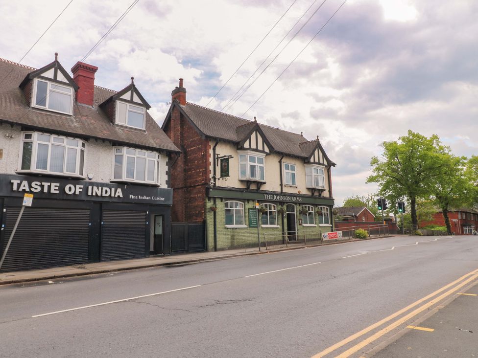 A street with Taste of India restaurant and The Johnson Arms pub at 57 Abbey Street