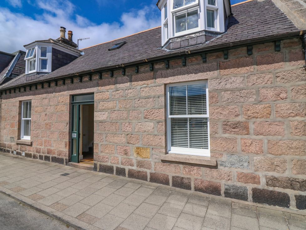 An outdoor view of a stone facade with windows and a door at St Kilda in Ballater