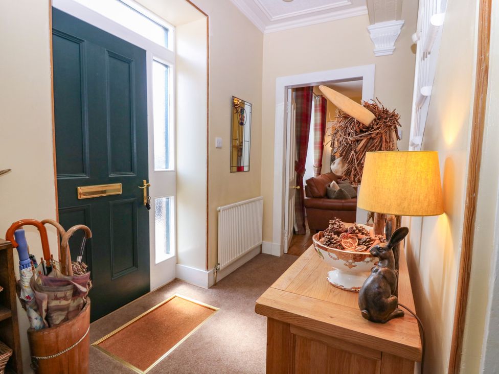A hallway with a front door and a decorative bowl on a console table at St Kilda in Ballater