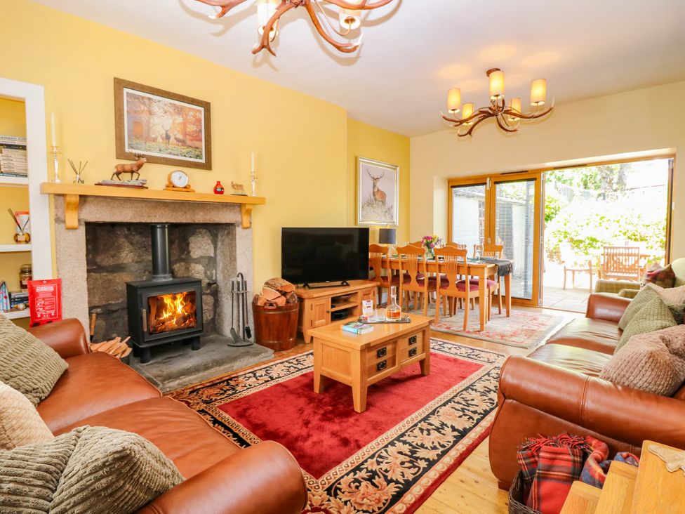 A living room with a fireplace and dining area at St Kilda in Ballater
