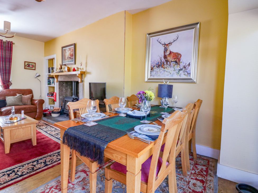 A dining room with a wooden table and chairs at St Kilda in Ballater