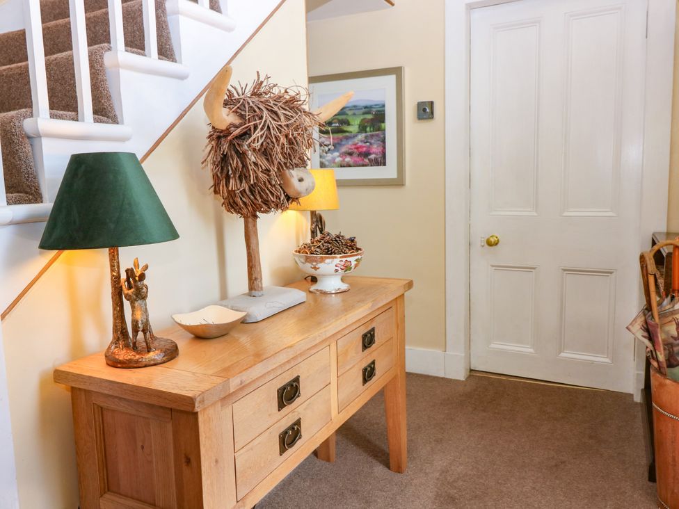 A hallway with a console table and decorative items at St Kilda in Ballater