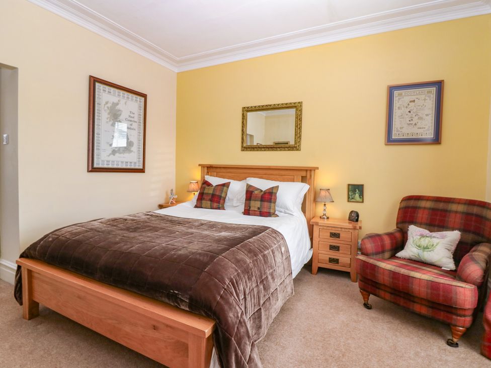 A bedroom with a bed and a chair at St Kilda in Ballater