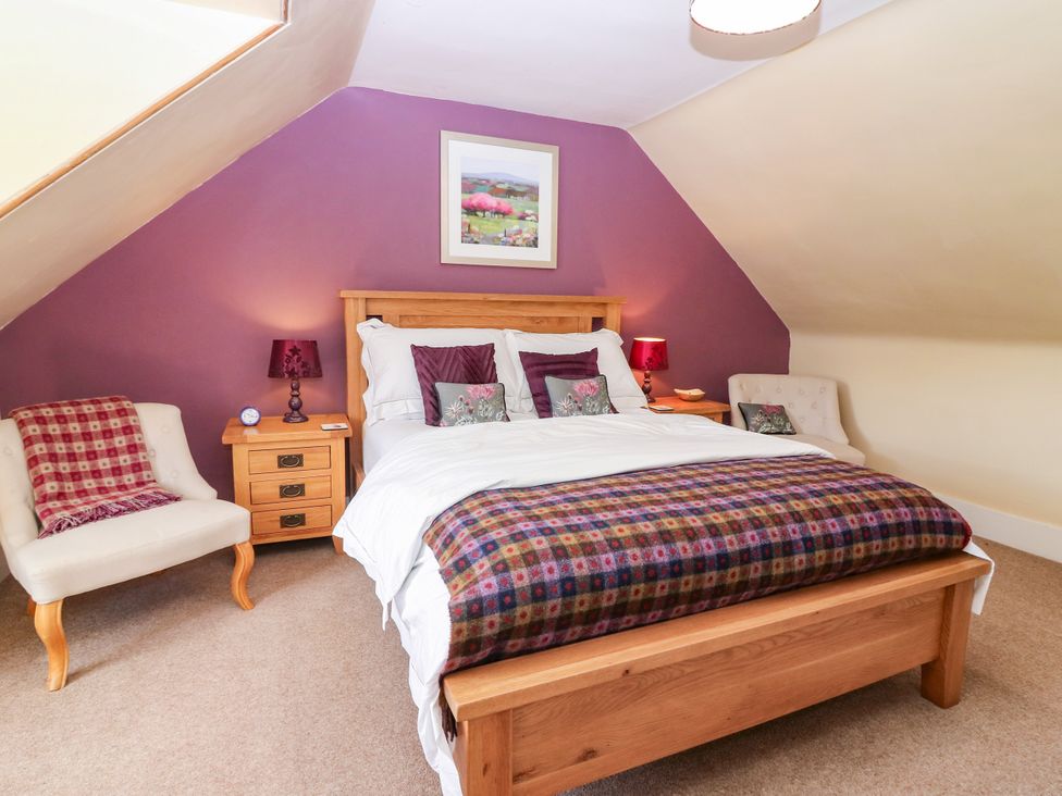 A bedroom with a bed and nightstand at St Kilda in Ballater