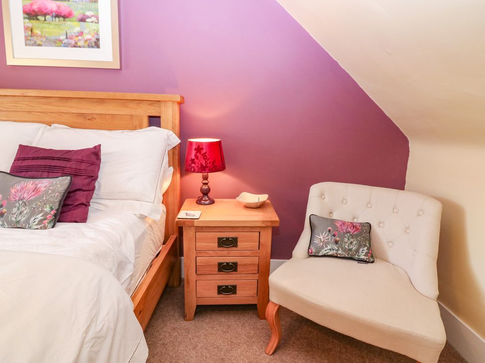 A bedroom with a bed and side table at St Kilda in Ballater