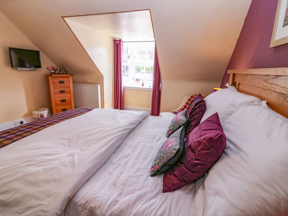 A bedroom with a bed and television at St Kilda in Ballater