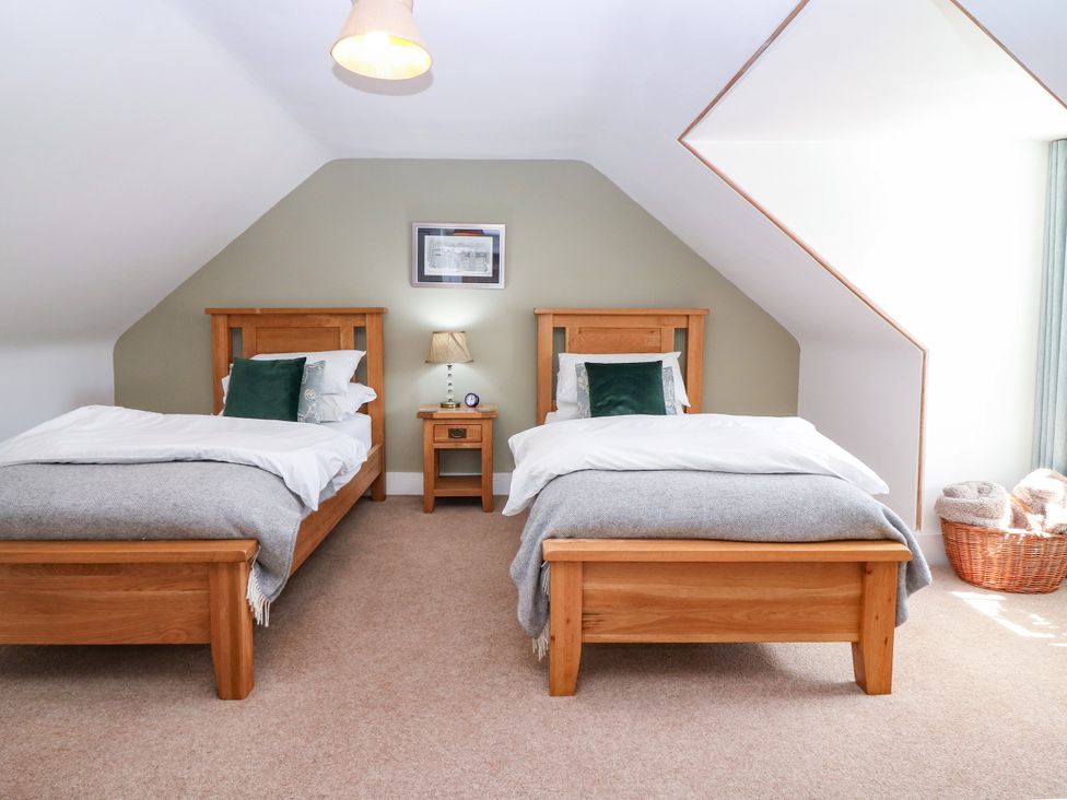 A bedroom with two beds and a nightstand at St Kilda in Ballater