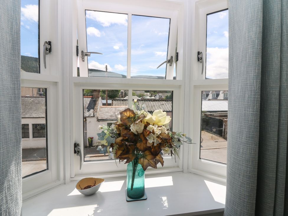 A window with a flower arrangement and a bowl at St Kilda in Ballater