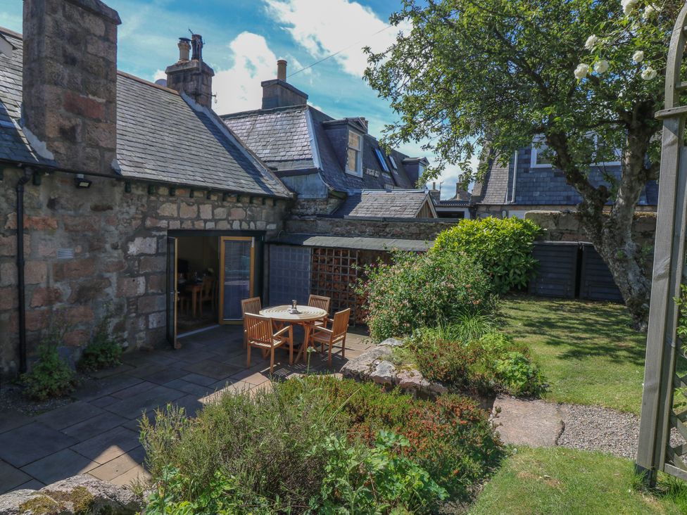 A garden with a table and chairs outside at St Kilda Ballater