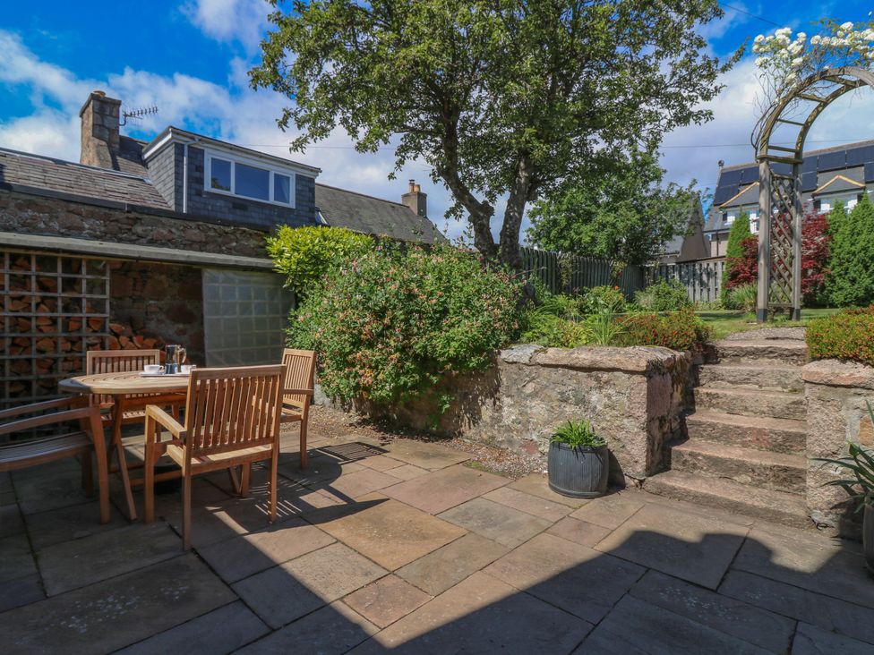A garden with a table and chairs at St Kilda in Ballater
