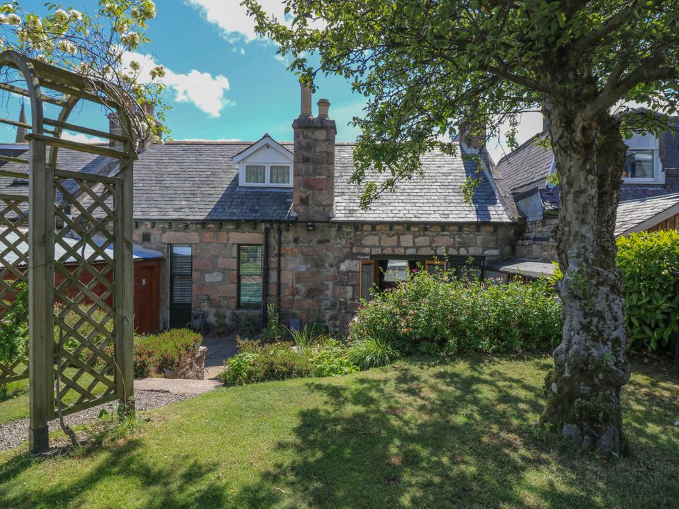 A garden with a house and tree at St Kilda in Ballater
