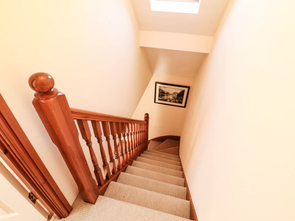 A staircase with a handrail and skylight at Derwent Cottage in Cockermouth