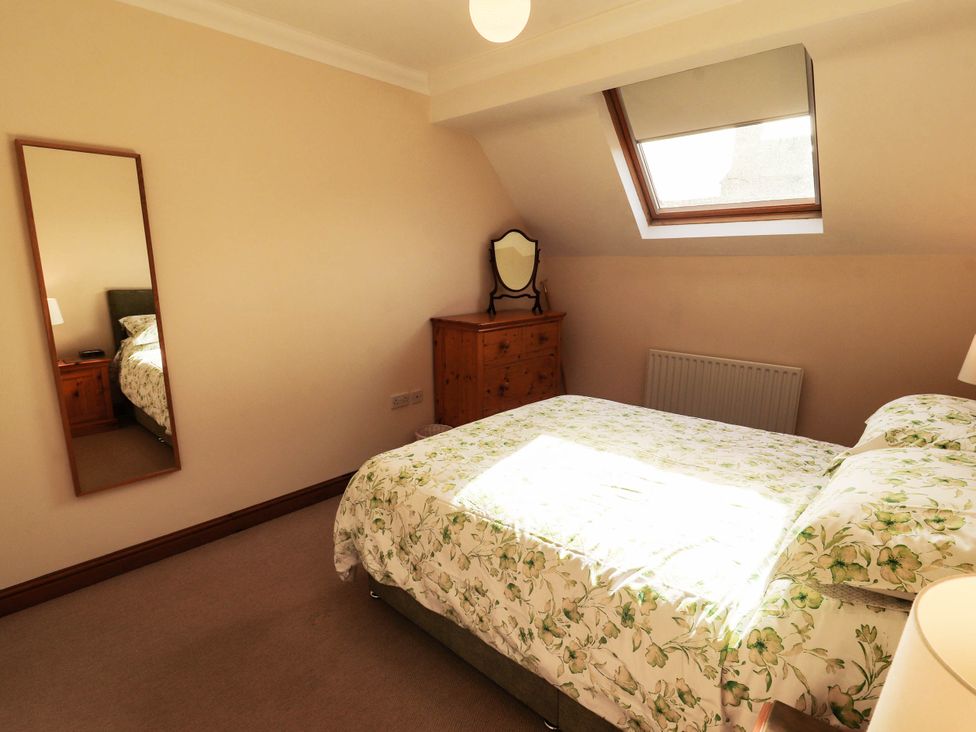 A bedroom with a bed and a dresser at Derwent Cottage in Cockermouth