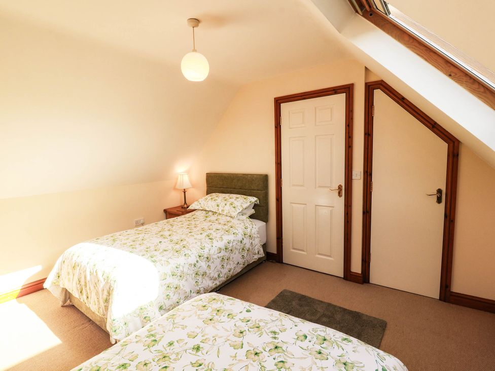 A bedroom with two beds and a lamp at Derwent Cottage in Cockermouth