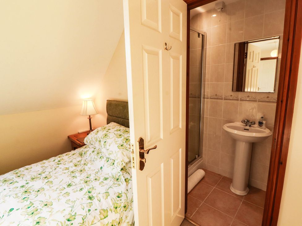 A bedroom with a bed and an attached bathroom at Derwent Cottage in Cockermouth