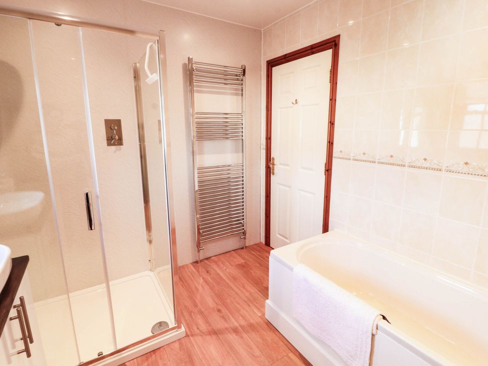 A bathroom with a bathtub and shower at Derwent Cottage in Cockermouth