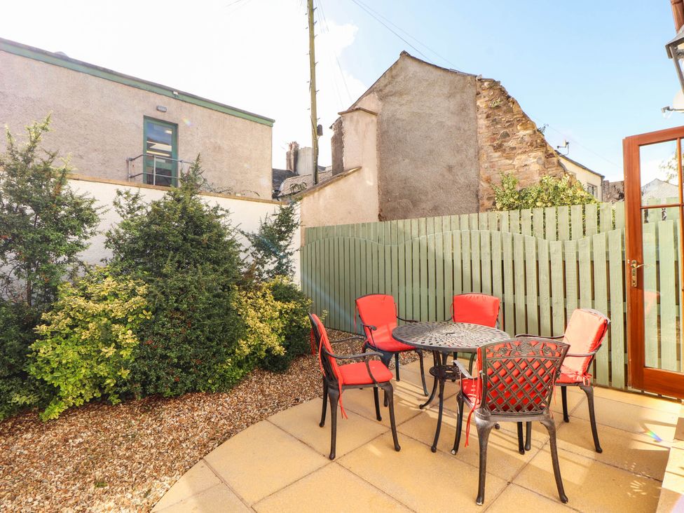 A garden with a table and chairs at Derwent Cottage in Cockermouth