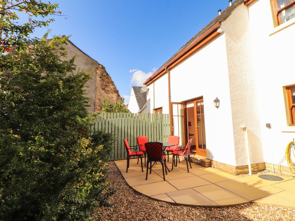 A garden with a table and chairs at Derwent Cottage in Cockermouth
