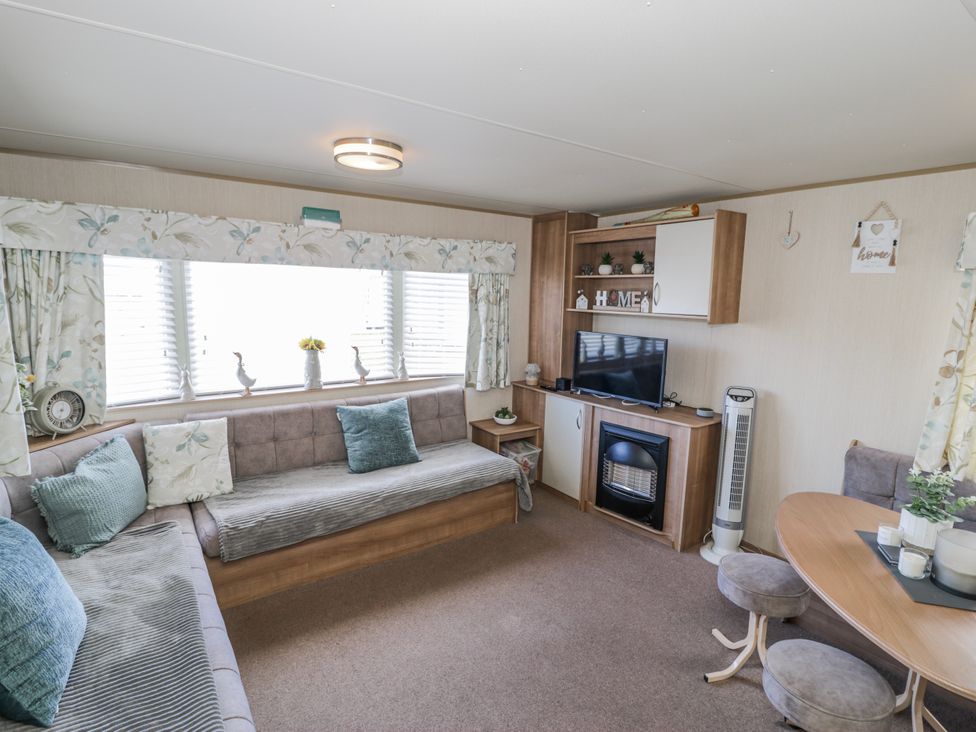 A living room with a sofa and television at 51 Silverbirch Way, Rhyl