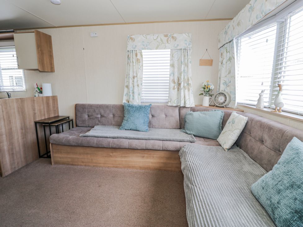 A living room with a sofa and decorative items at 51 Silverbirch Way Rhyl
