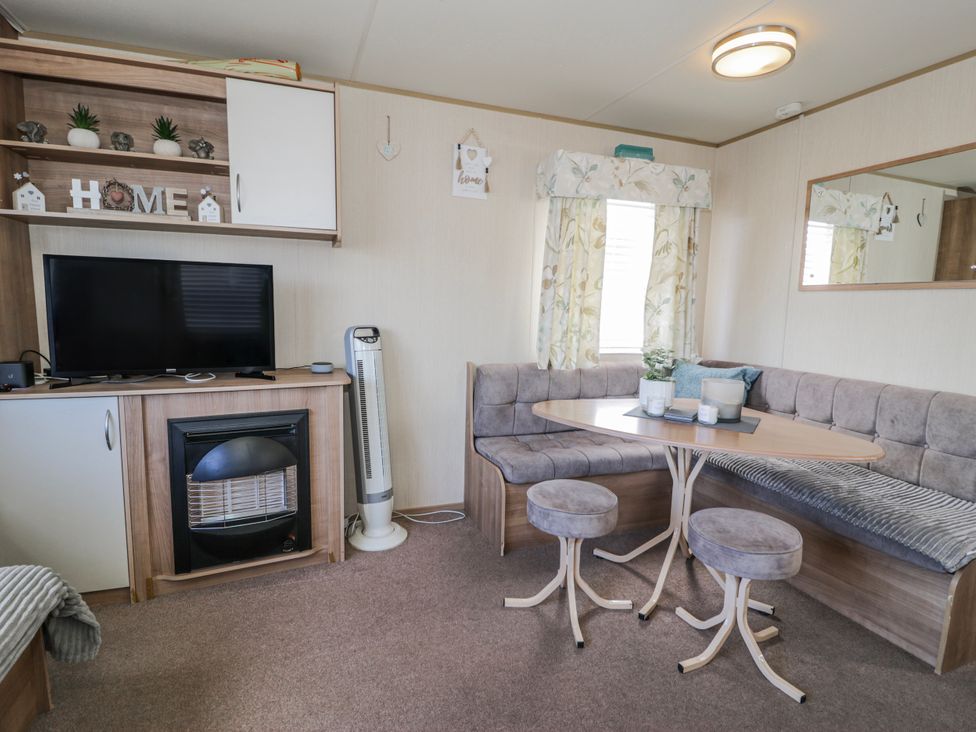 A living room with a television and a dining area at 51 Silverbirch Way in Rhyl