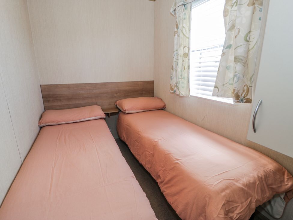 A bedroom with two beds and a window at 51 Silverbirch Way, Rhyl