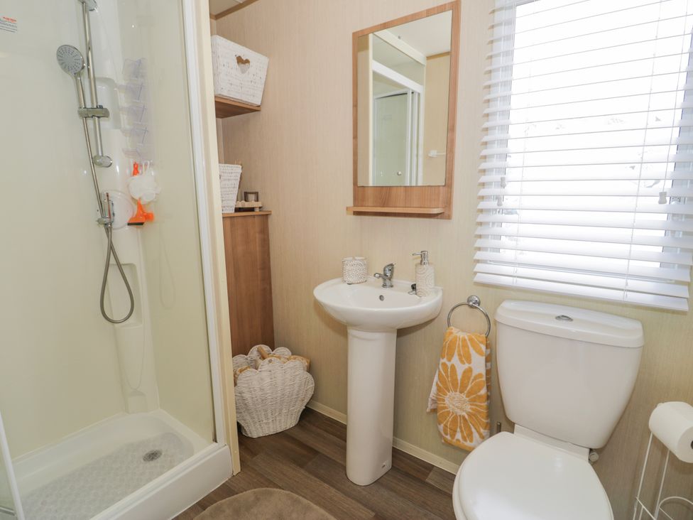 A bathroom with a shower, sink, and toilet at 51 Silverbirch Way Rhyl