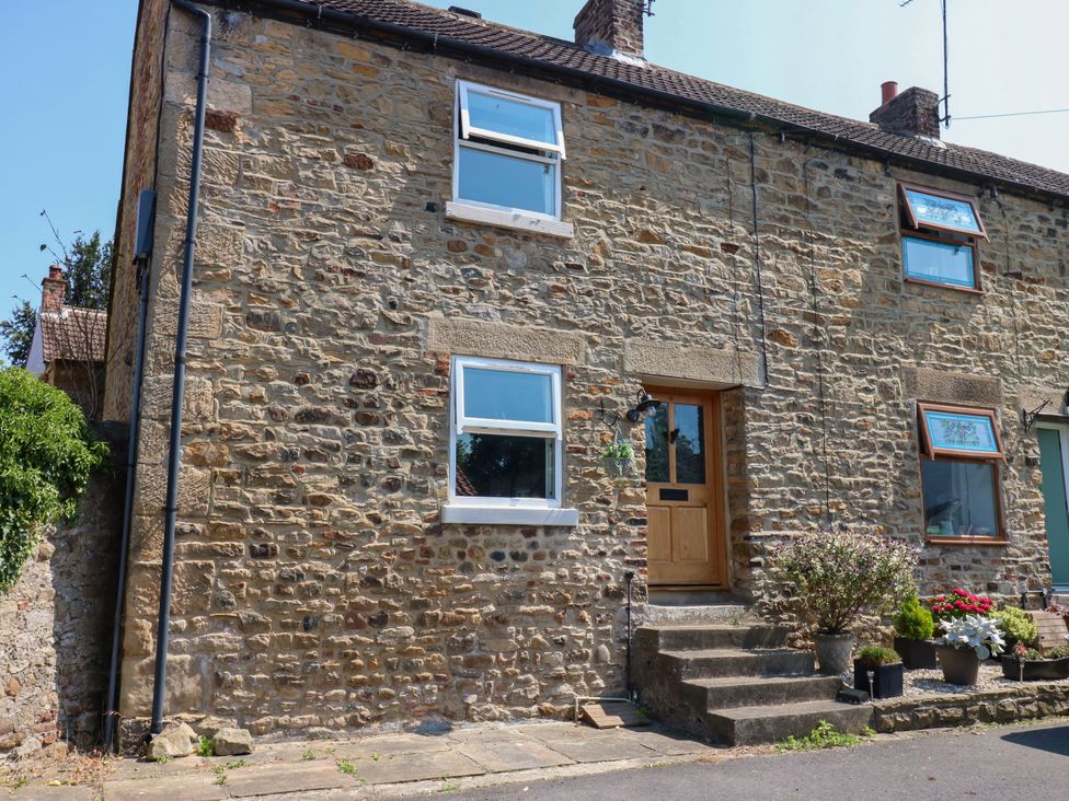 A stone house exterior with a front door and windows at 14 The Porch Barton