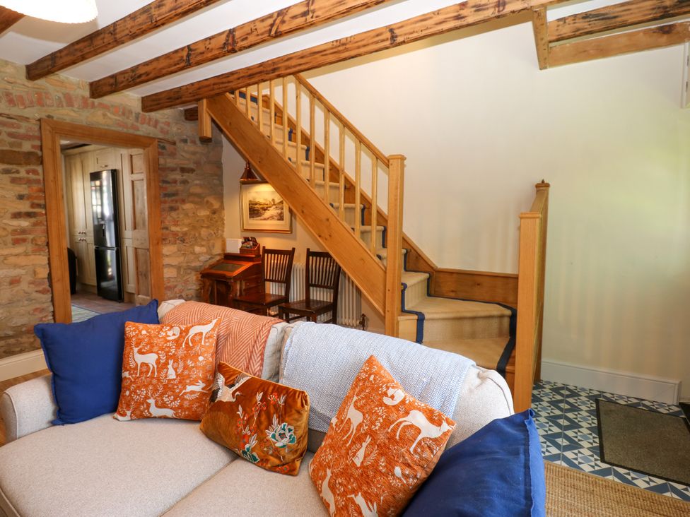 A living room with a sofa and staircase at 14 The Porch in Barton