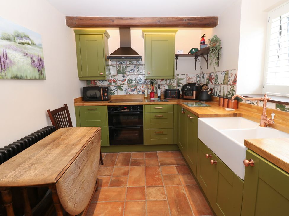 A kitchen with green cabinets and wooden countertops at 14 The Porch in Barton