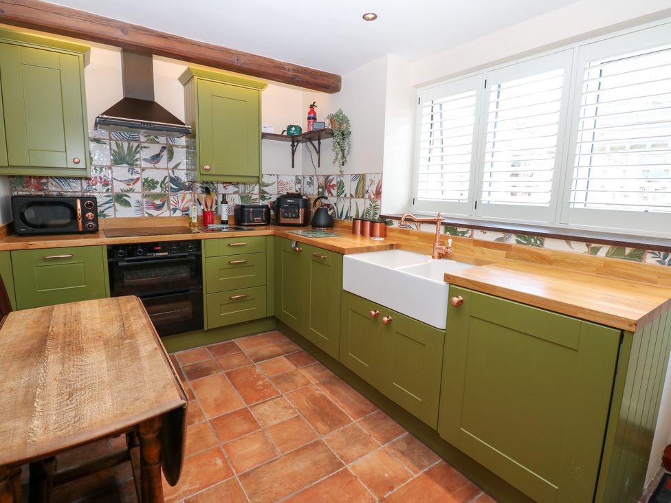 A kitchen with green cabinets and a wooden countertop at 14 The Porch in Barton