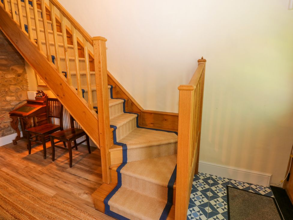 A staircase with wooden railing in a hallway at 14 The Porch in Barton