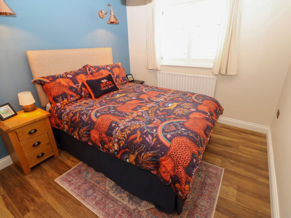A bedroom with a bed and bedside table at 14 The Porch in Barton