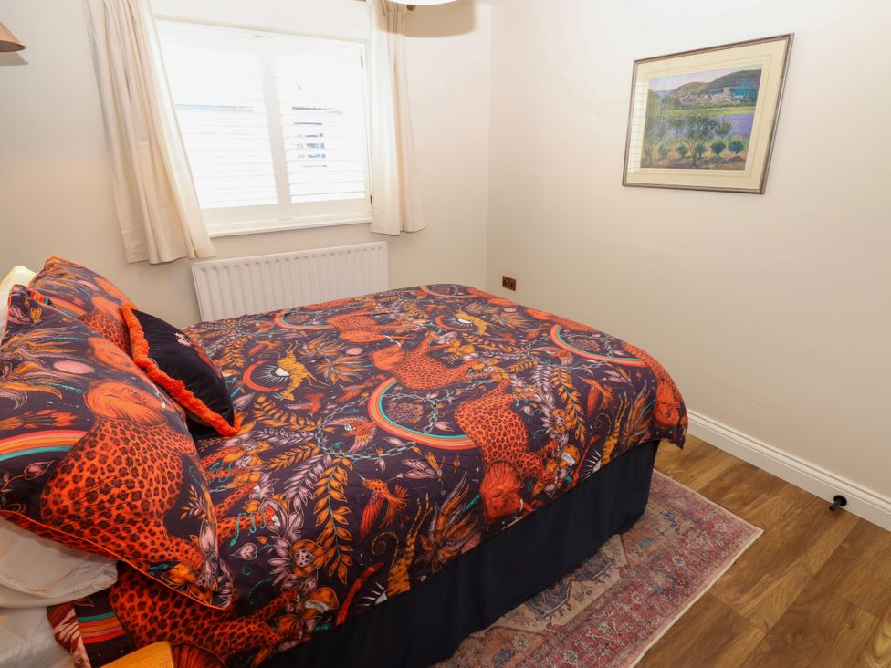 A bedroom with a bed covered in patterned bedding at 14 The Porch, Barton