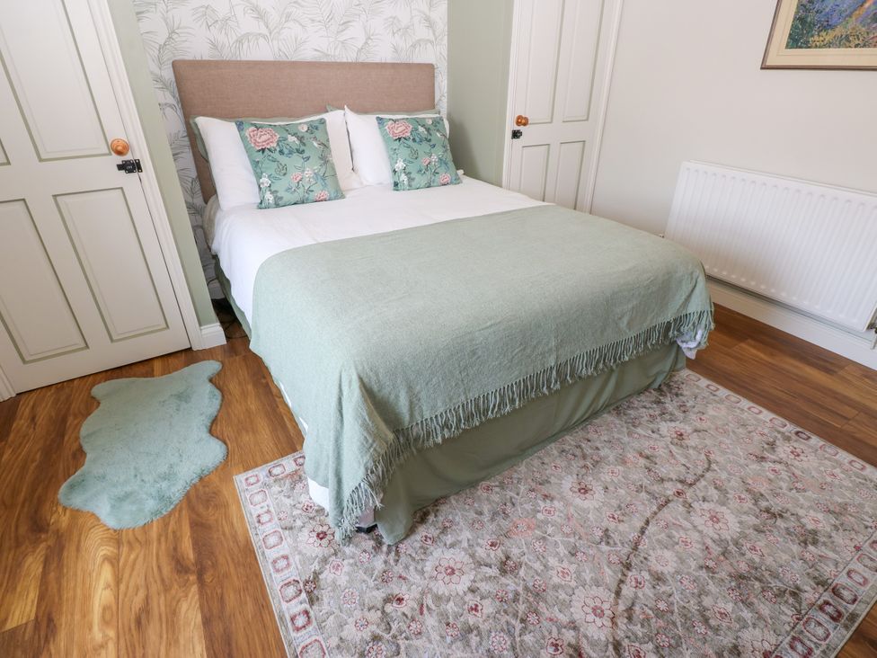 A bedroom with a bed and rug at 14 The Porch Barton