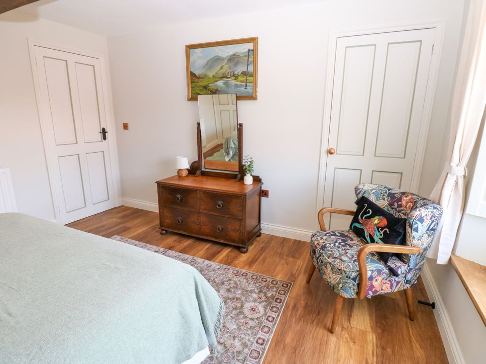 A bedroom with a dresser and a chair at 14 The Porch in Barton
