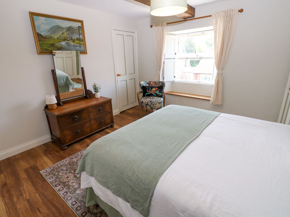 A bedroom with a bed and a mirror at 14 The Porch in Barton