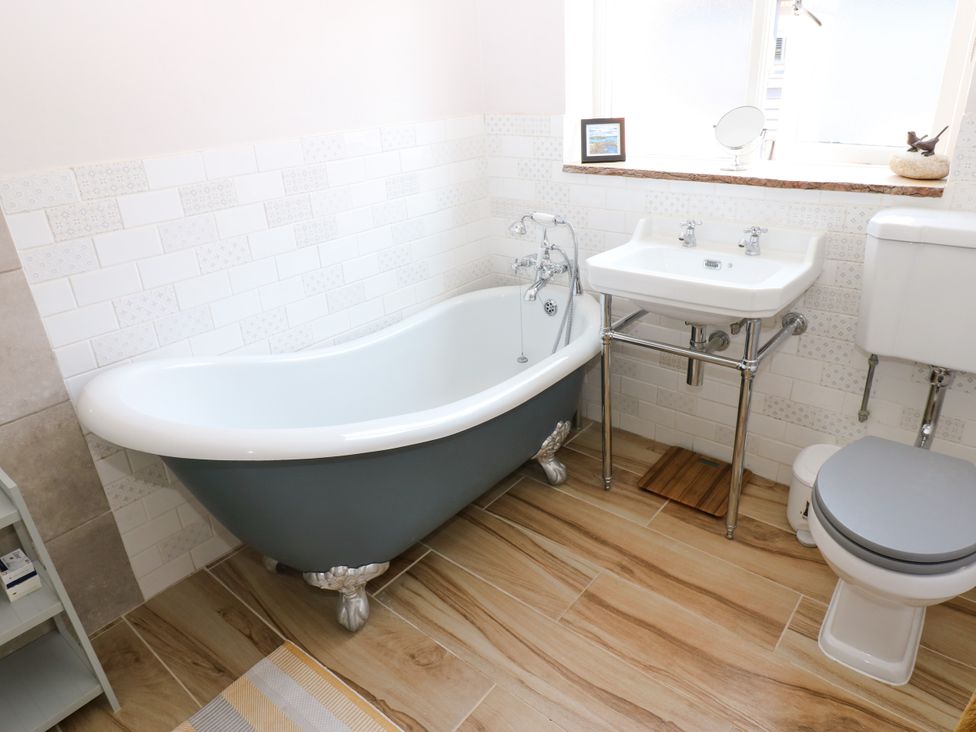 A bathroom with a bathtub, sink, and toilet at 14 The Porch in Barton