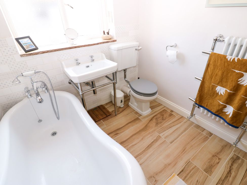 A bathroom with a bathtub, sink, and toilet at 14 The Porch in Barton