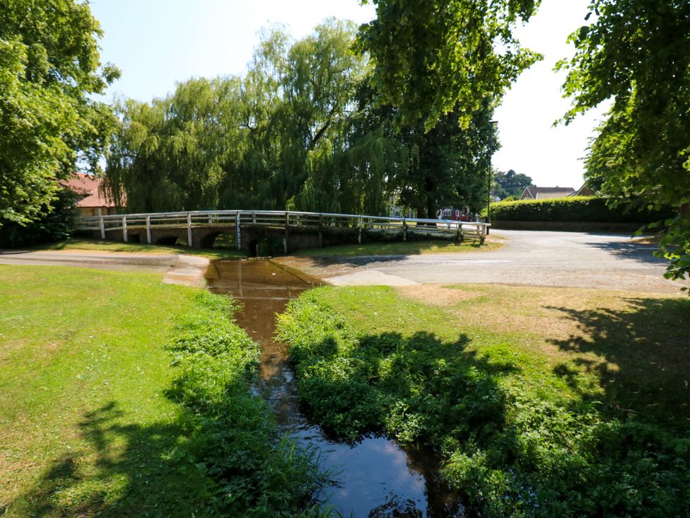 A bridge over a stream in a park at 14 The Porch Barton