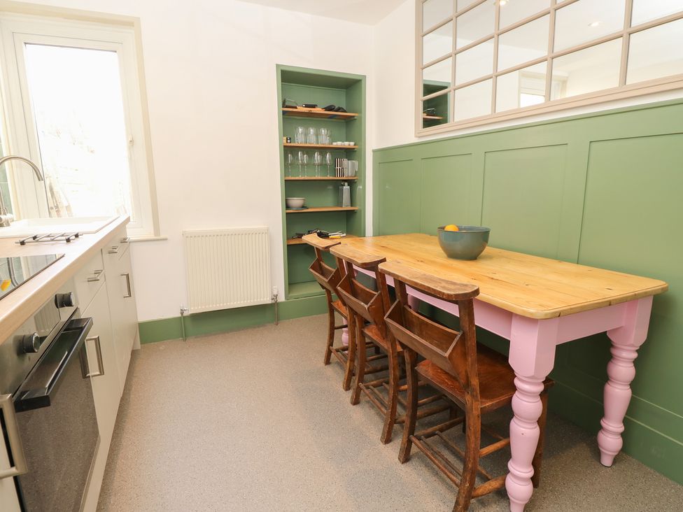 A kitchen with a table and chairs at 8 Manor Villas Totland Bay