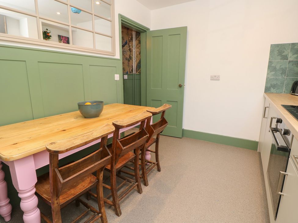 A dining room with a table and chairs at 8 Manor Villas in Totland Bay