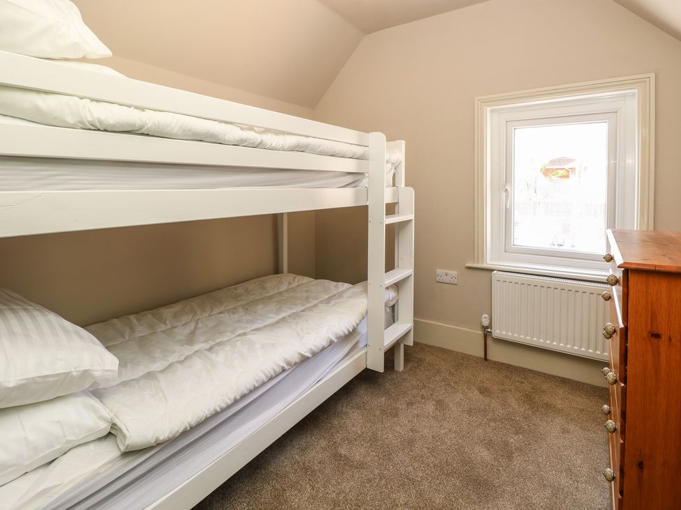 A bedroom with a bunk bed and dresser at 8 Manor Villas Totland Bay
