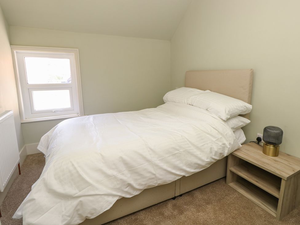 A bedroom with a bed and nightstand at 8 Manor Villas in Totland Bay