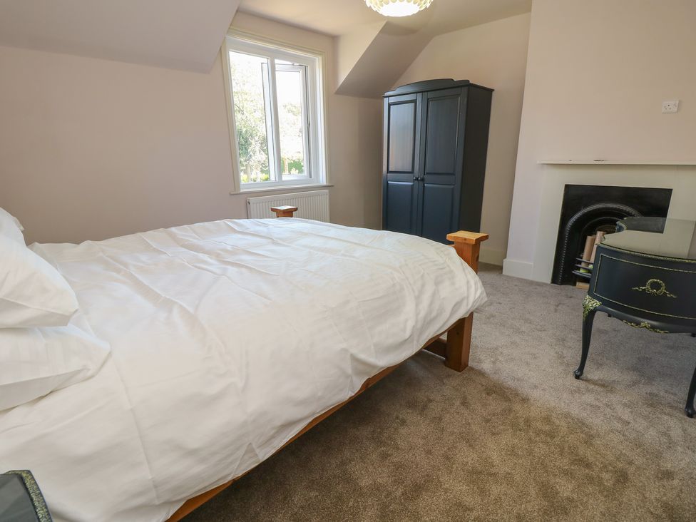 A bedroom with a bed and wardrobe at 8 Manor Villas in Totland Bay