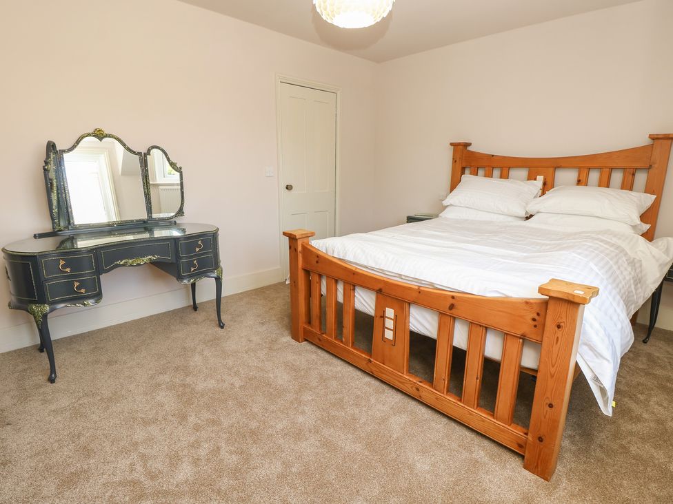 A bedroom with a bed and dresser at 8 Manor Villas in Totland Bay