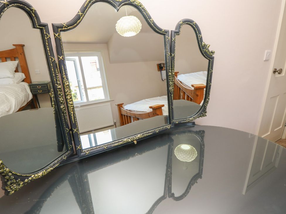 A bedroom with a dressing table and beds at 8 Manor Villas Totland Bay